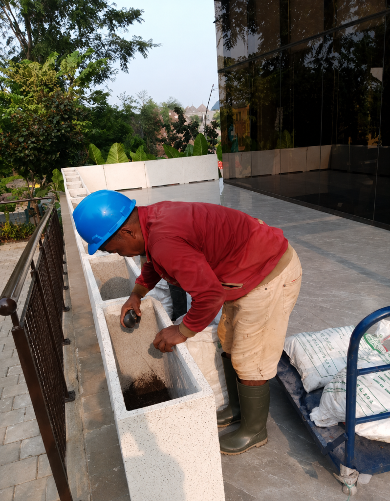 Proses pekerjaan lanskap pengirisan batu krikil pada pot barier